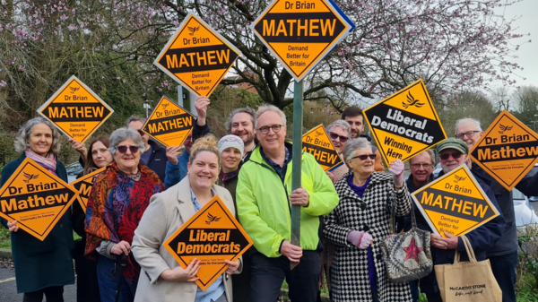Group photo of Brian with volunteers holding up orange lib dem diamonds